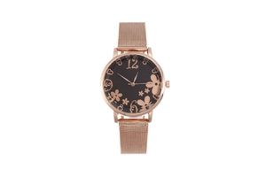 Detailed macro view of black dial with rose gold flower patterns and milanese mesh band