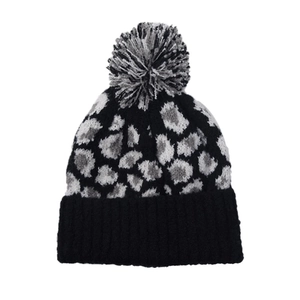 Detailed view of winter leopard print knit beanie with a fluffy faux fur pompom top
