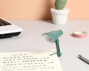Vue détaillée d'une mini lampe de lecture LED verte avec clip fixée sur un carnet de notes