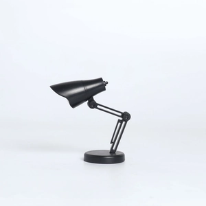 Mini lampe de bureau LED noire avec bras articulé et base ronde sur fond blanc pur