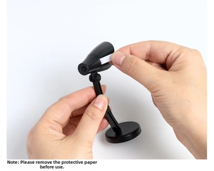 Retrait de la languette isolante de la pile d'une mini lampe LED noire avant l'activation