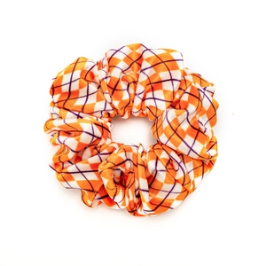 Orange and white checkered velvet scrunchie for Halloween hair styling on white background