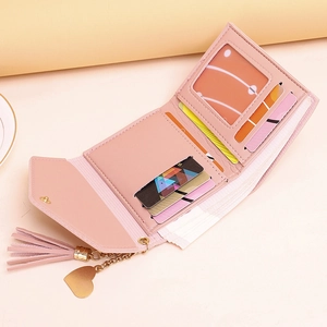 Elegant pink faux leather trifold wallet for women featuring a tassel and heart charm