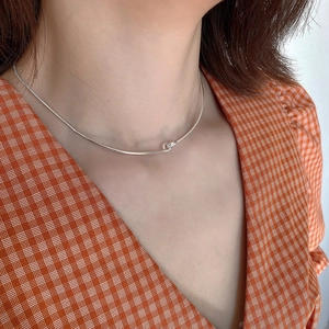 Detail of a 925 sterling silver minimalist knotted choker on a model's neck