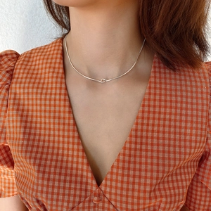 Minimalist 925 sterling silver knotted chain choker necklace shown on a female model