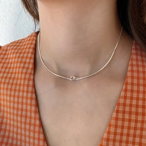 Close-up of minimalist S925 sterling silver knotted chain necklace on a model