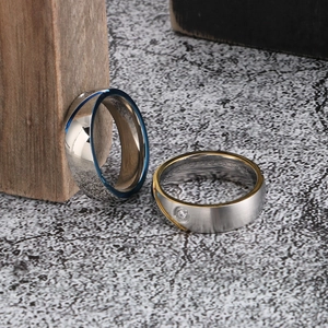 Macro detail of minimalist two-tone steel rings with brushed finish and inlaid crystal