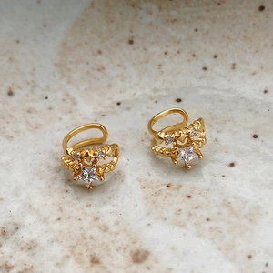 Macro shot of 925 sterling silver star ear cuffs with gold plating and white cubic zirconia