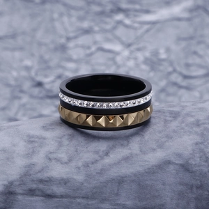 Gros plan détaillé d'une bague triple épaisseur avec anneaux noir, argenté et doré