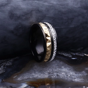 Détail d'une bague large tendance sertie de cristaux sur fond de pierre noire texturée