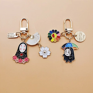 Detail of enamel keychains featuring No-Face character with heart and umbrella motifs