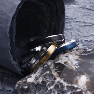 Detailed view of brushed and polished stainless steel rings in black, gold, and blue colors