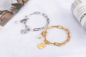 Close-up of gold and silver pearl T-bar chain bracelets with angel charms