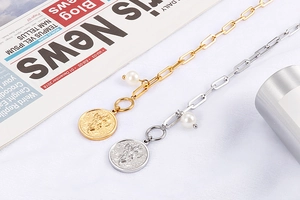 Detail of gold and silver clip necklaces with pearl pendant and cupid relief charms