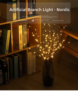 Detailed close-up of warm yellow LED willow branch lights in a dark glass vase decor