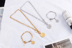 Détail de bracelets or et argent avec pendentifs arbre de vie, perles et fermoirs en T