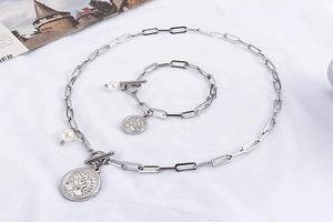 Détail du collier et bracelet chaîne trombone argentée avec pendentif arbre de vie