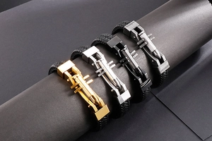 Detail of masculine braided leather bracelets featuring mechanical bullet-shaped metal clasps