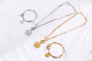 Détails de colliers de perles et de bracelets de pièces en or et argent sur soie