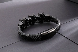 Dettaglio di un bracciale da uomo in pelle intrecciata con chiusura in acciaio nero
