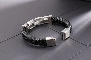 Close-up of black braided leather bracelet with brushed stainless steel clasp detail