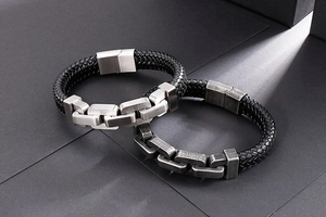 Detail of woven black leather bracelet with vintage stainless steel magnetic clasp and chain