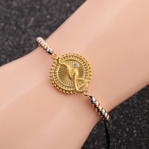 Detail of beaded bracelet with gold snake charm and sparkling cubic zirconia accent