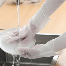 Close-up of white waterproof cleaning gloves washing a ceramic plate under a faucet