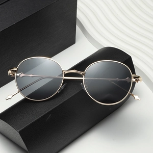 Retro oval sunglasses with gold metal frames and black lenses on elegant background
