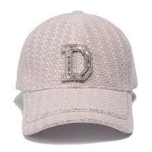 Close-up of pink tweed baseball cap featuring rhinestone letter D and sparkling brim detail