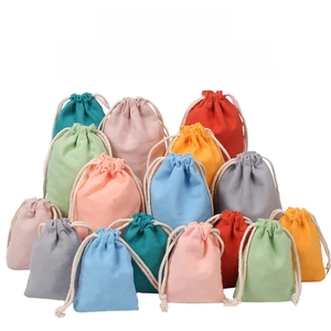 Detailed pile of colorful cotton drawstring gift bags in multiple vibrant pastel shades