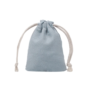 Detail showing light blue cotton drawstring pouch with textured fabric and knotted ropes