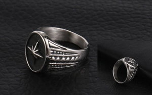 Macro detail of silver vintage compass star relief on a textured titanium steel ring