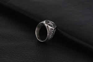 Detail of vintage silver titanium steel ring with star engraving on black leather