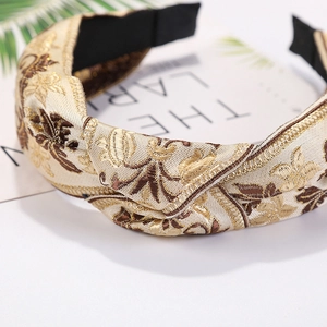 Close-up of golden and brown brocade knotted headband with intricate embroidery details