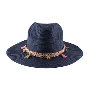 Dettaglio di cappello in paglia blu scuro con nastro etnico, nappe colorate e conchiglie