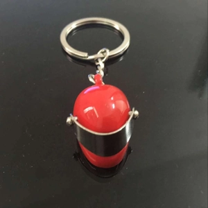 Creative red motorcycle helmet keychain with metal chain on reflective surface