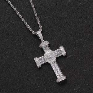Silver hip hop cross pendant necklace with clear cubic zirconia on a dark background