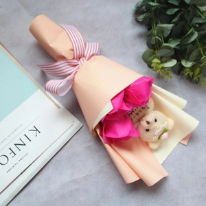 Detail of rose soap flower bouquet with small white teddy bear in pink gift wrap