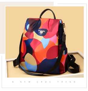 Close-up of colorful patchwork oxford backpack with POLABA gold logo and black handles