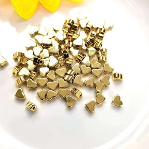 Close-up of small 14K gold filled heart-shaped spacer beads for DIY jewelry making