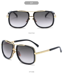 Detail view of large frame sunglasses with black and gold double bridge and gradient lenses