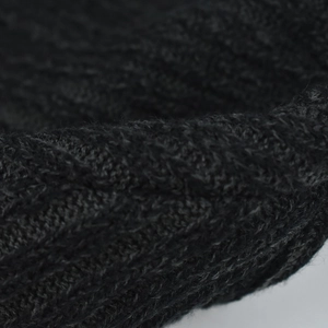 Macro view of black cable knit pattern showing soft thick texture of the winter wool hat