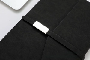 Detail of premium black business notebook with silver metallic buckle and matte texture