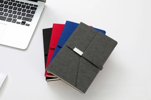 Close-up of four-color matte leather business notebooks with metallic buckle closures