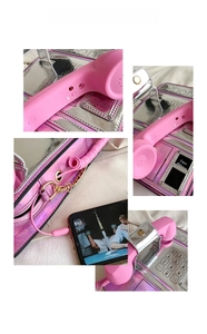 Detail of pink retro telephone bag with laser silver finish and 3.5mm audio jack