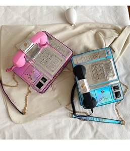 Close-up of creative retro phone-shaped crossbody bags in laser pink and blue finish