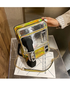 Detail of creative vintage telephone bag in iridescent gold and silver with chain