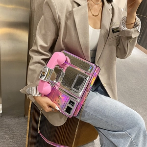 Vista detallada del bolso de hombro holográfico en forma de teléfono con auricular rosa.