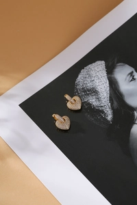 Luxurious gold heart stud earrings with pave-set sparkling zircon on vintage background
